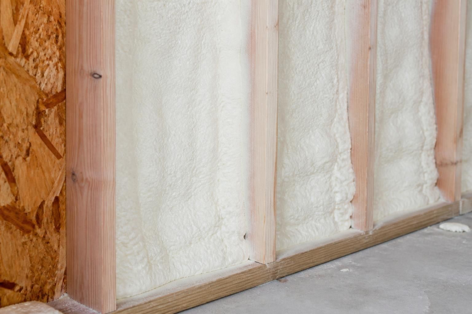 Neatly applied spray foam insulation inside a wall cavity.